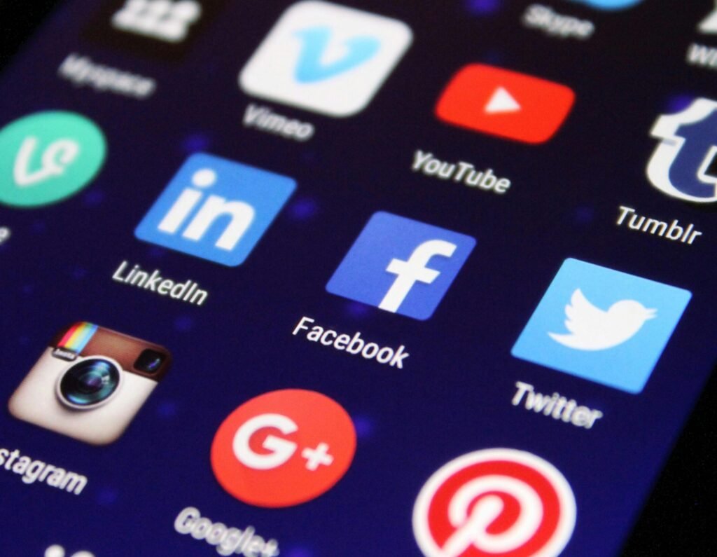 Close-up of a smartphone screen showing various social media app icons such as Facebook and Twitter.